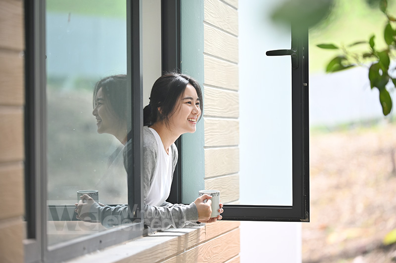 girl smiling standing inside aluminium window